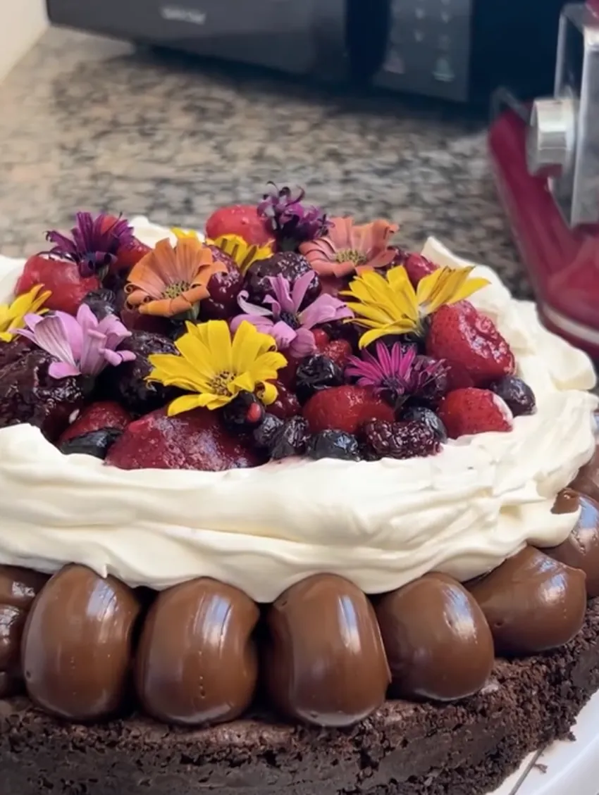 Torta de chocolate con frutos rojos y flores comestibles